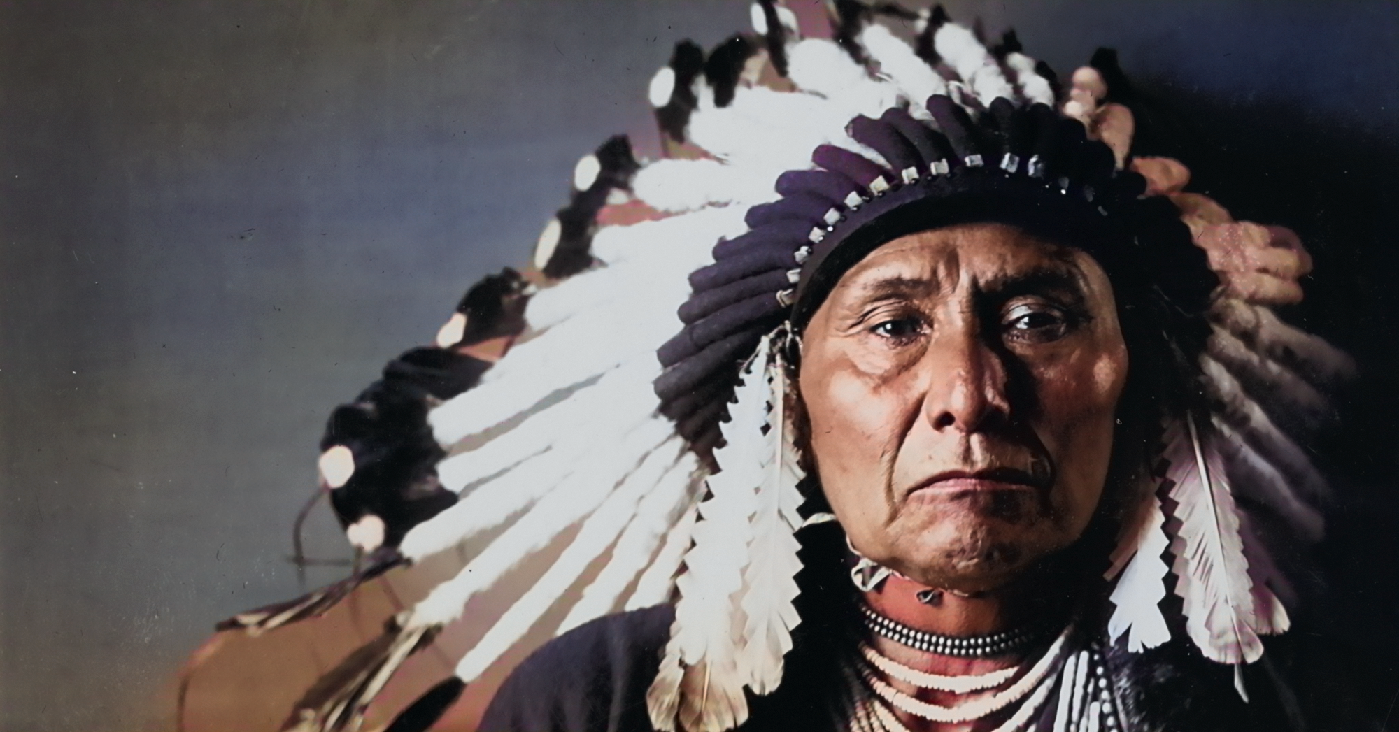 Colorized photograph of Chief Joseph in traditional headdress