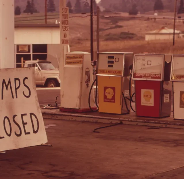 Gas station with closed pumps and a sign reading 'PUMPS CLOSED' during the 1973 OPEC oil embargo.